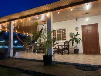 Tropical porch with string lights hammocks plants at beach villa Malibu Gorgona Panama
