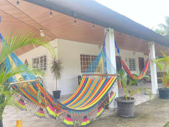 Covered porch with colorful hammocks potted plants tropical bungalow Malibu beach house Panama