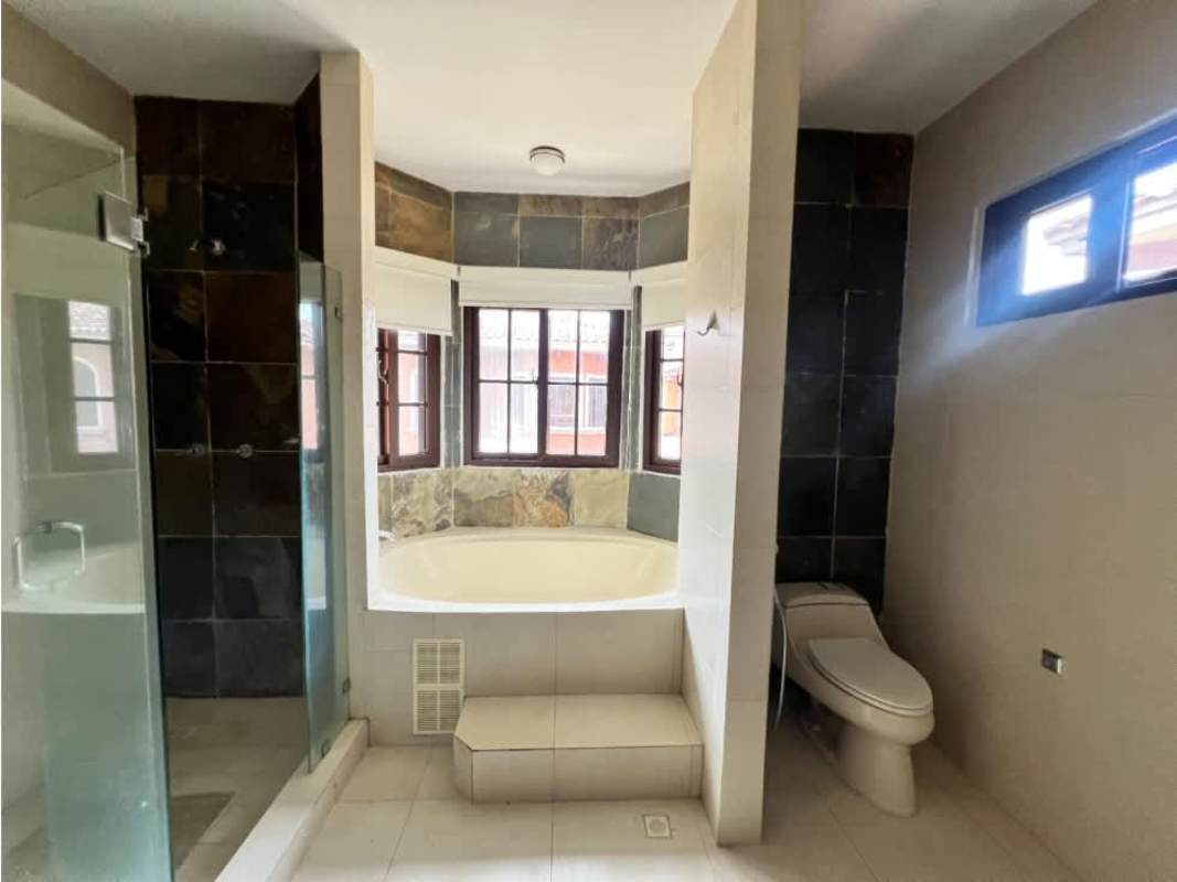 Bathroom with corner tub, glass shower enclosure, tiled walls in Costa Sur luxury home Panama