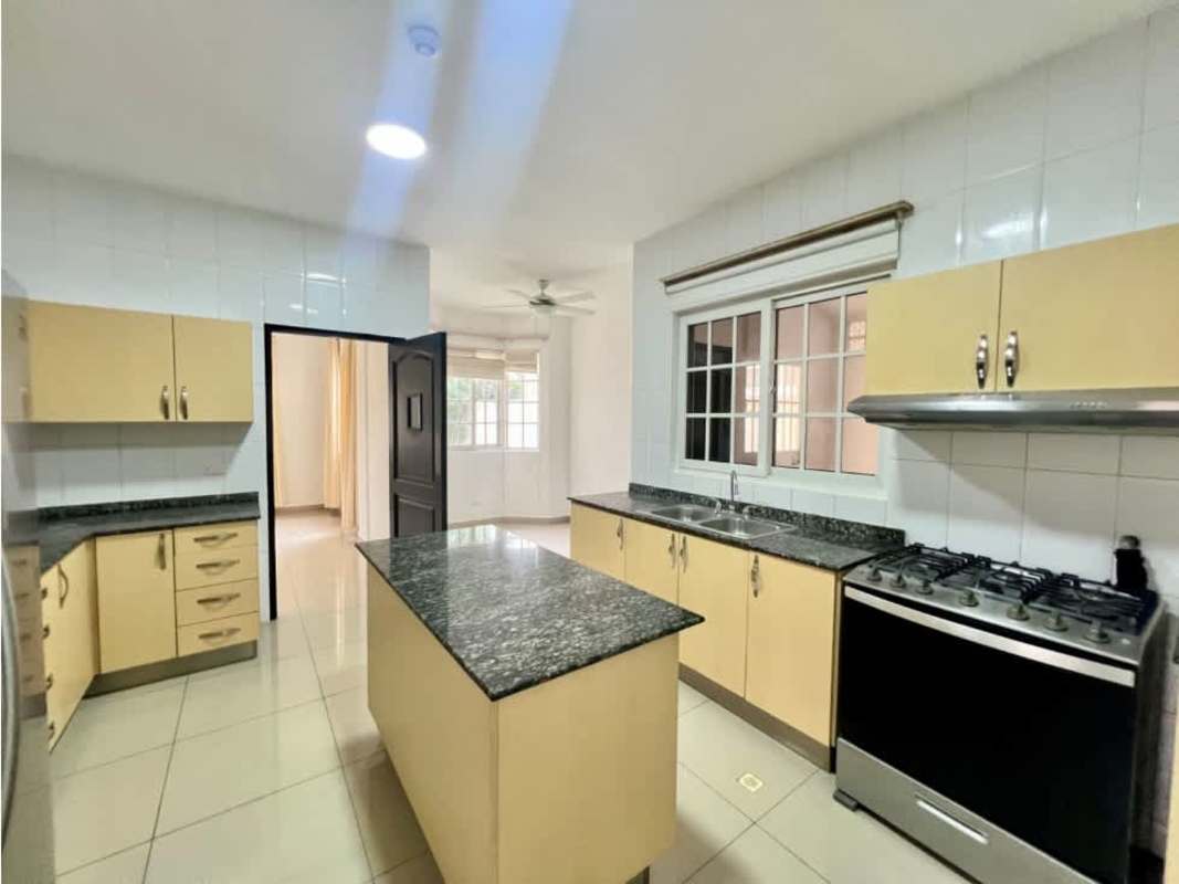 Modern kitchen with granite, gas stove, and island in Villa Valencia Costa Sur Panama