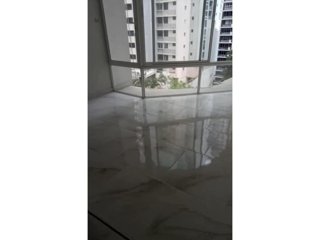 Bright living room with marble floors panoramic floor to ceiling windows ocean view Punta Paitilla Panama City condo