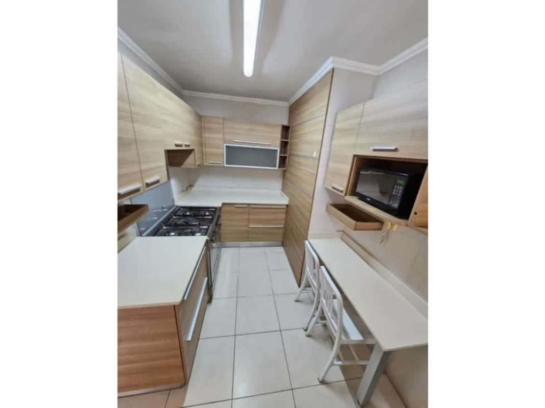 Modern kitchen with light wood cabinets, breakfast bar, integrated appliances PH Royal Pacific Punta Pacifica Panama