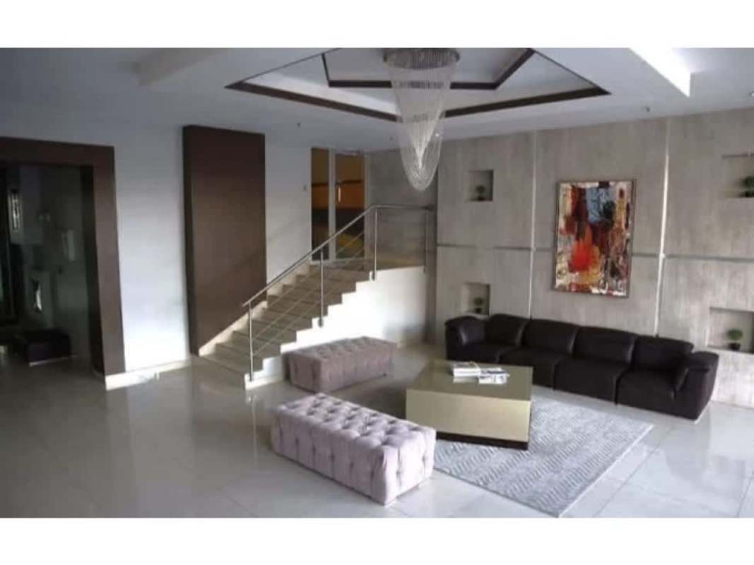Luxury living room with floating staircase, chandelier, modern art in PH Diamond Tower Panama City