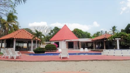 Sun loungers by pool lush landscaping covered gazebos tropical feel Playa Gorgona Panama