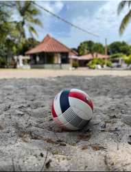 Sandy volleyball court with tropical bungalows and palm trees at Panama beach retreat