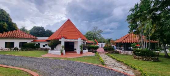 Mediterranean style estate with red tile roofs, white walls lush tropical gardens in Panama