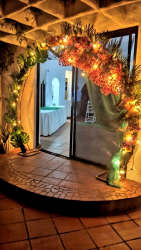 Indoor foyer event space with bright floral arch and glass doors at Playa Gorgona beach villa