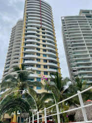 Modern beachfront condominium high-rises with palm trees and pathway at PH Playa Serena Playa Gorgona