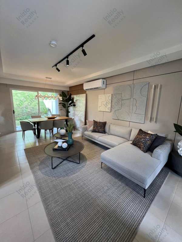 Open-plan living and dining area with sectional sofa and garden views in townhouse Brisas del Golf Panama