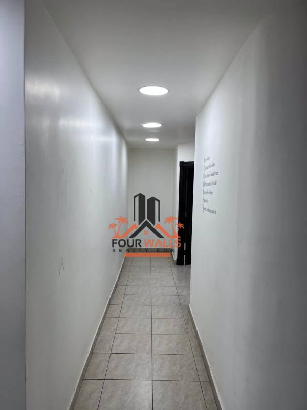Narrow hallway with white walls, tile floor in office for rent Panama
