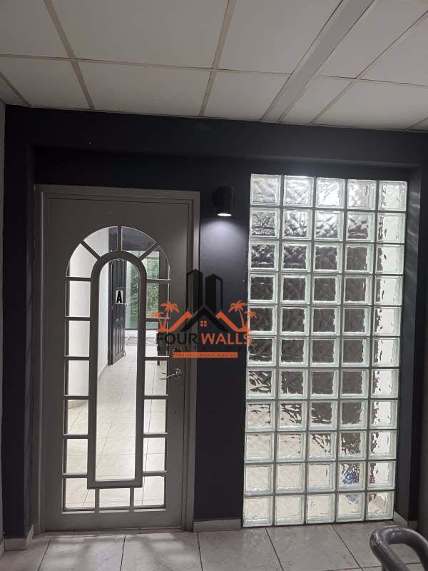 Hallway with arched glass door, glass block wall in business plaza office Panama