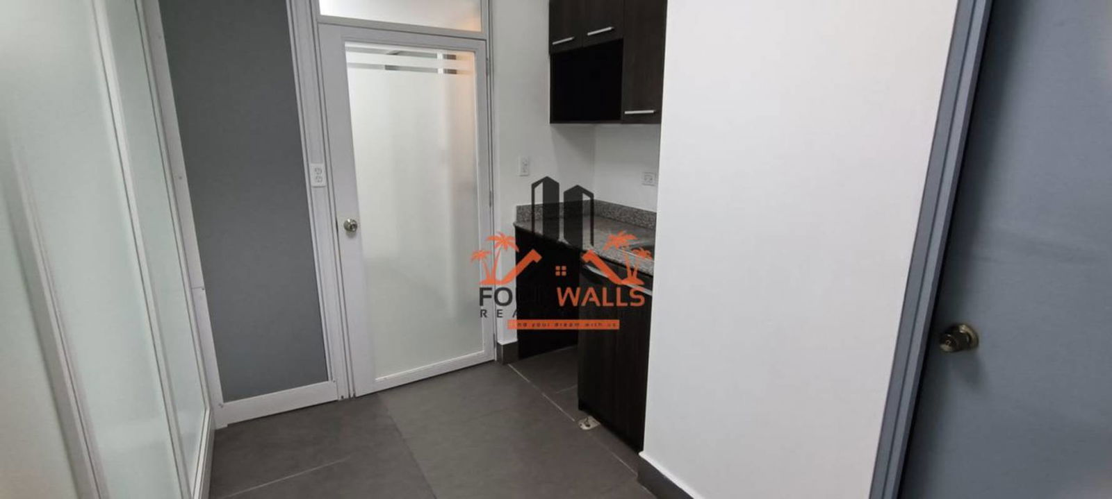 Office bathroom featuring stylish stone accent wall at PH Twist Tower Panama