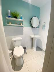 Bathroom with light blue two-tone wall, pedestal sink, mirror in apartment at PH Valle del Río