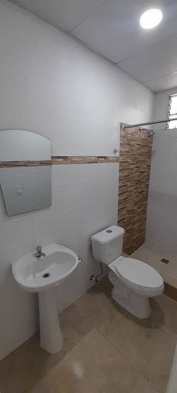 Bathroom with pedestal sink walk-in shower tile wall accents Villa de Las Acacias Panama