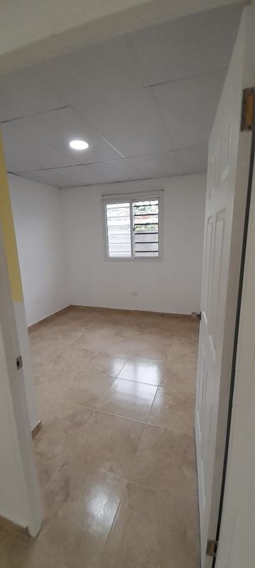 Minimalist bedroom with built-in closet natural light tiled floor in Llano Bonito Panama