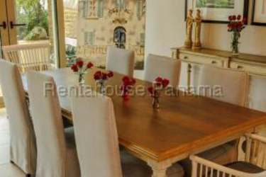 Living room with wood beams, blue sofa, sliding doors to patio in Playa Escondida villa Panama