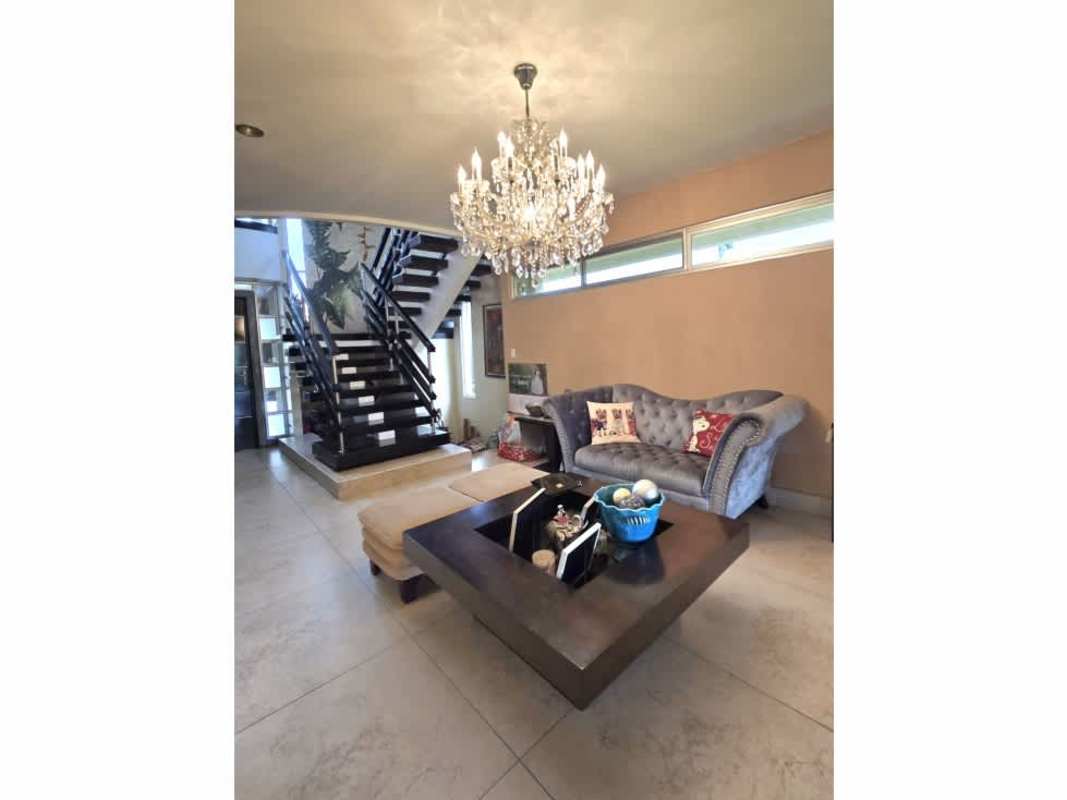 Contemporary living area with floating stairs, chandelier and sectional sofa in Altos de Panamá luxury house