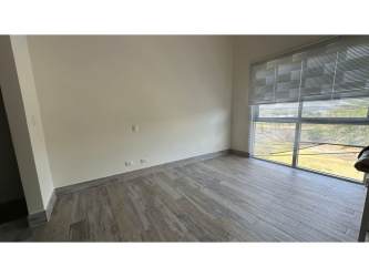 Bedroom with large windows, wood-style flooring in PH Mosaic Panama Pacifico apartment