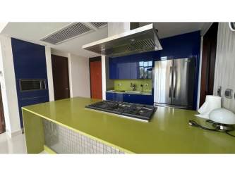 Island kitchen with modern stainless appliances and tile backsplash in PH Mosaic Panama Pacifico