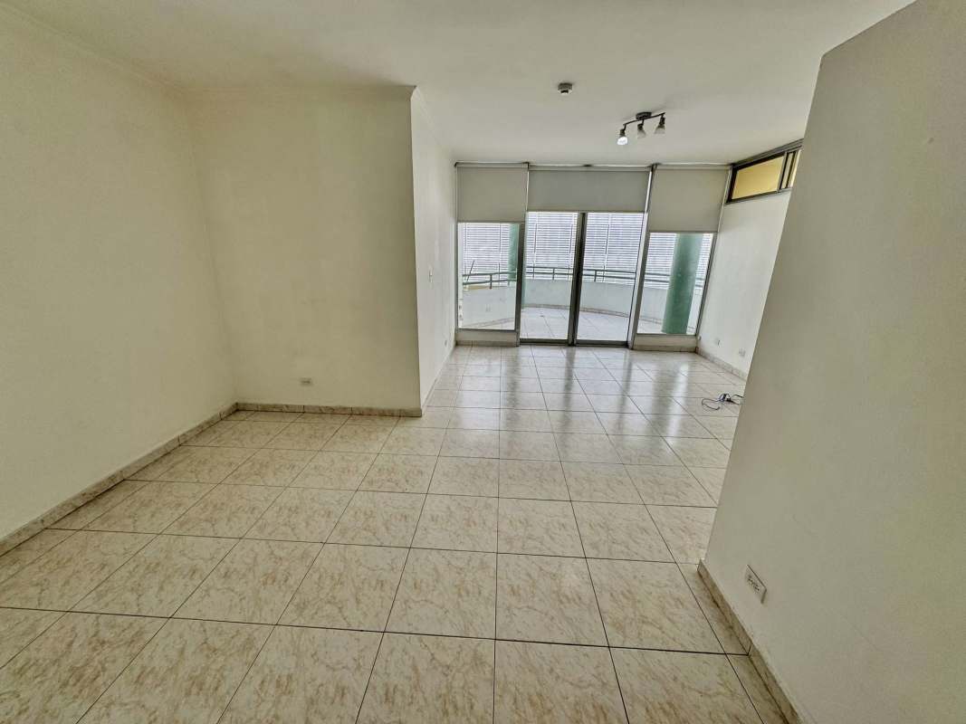 Large living room with bright tile floors, sliding doors to balcony at PH Deveaux in San Francisco Panama City