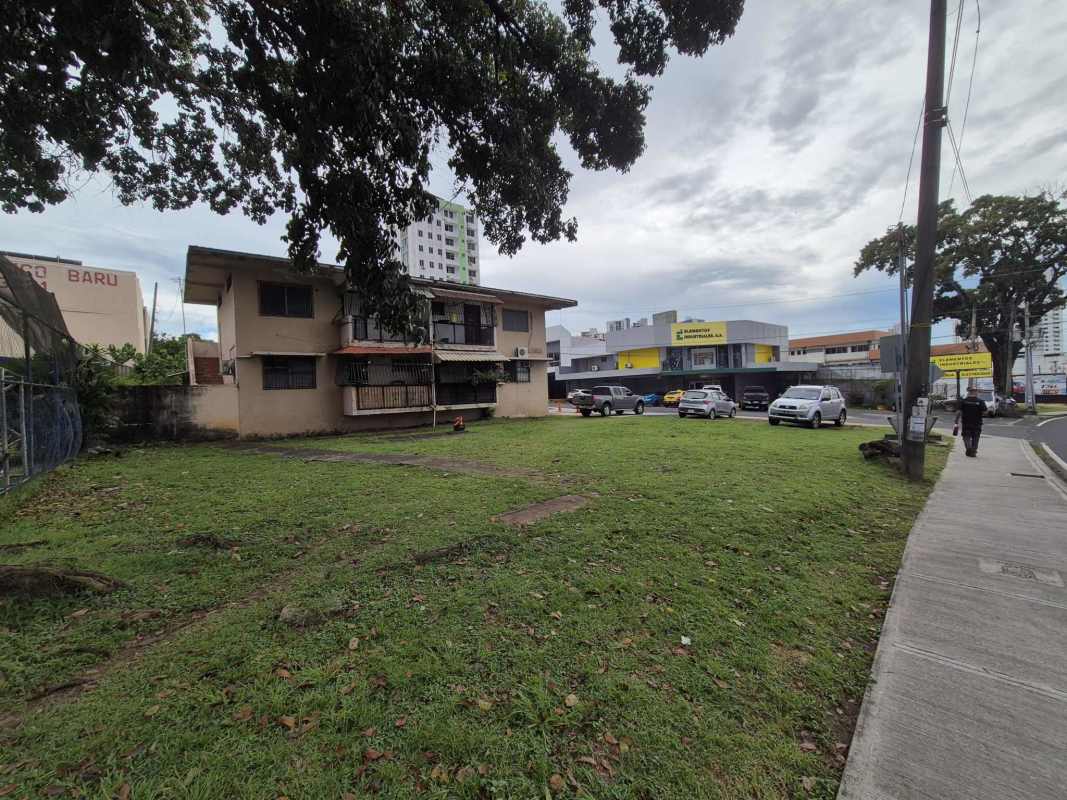 Two-story beige building with grassy yard near main roads in Carrasquilla Panama