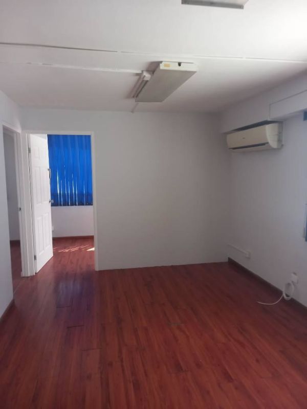 Empty room with laminate flooring, large window blinds in apartment Parque Lefevre Panama