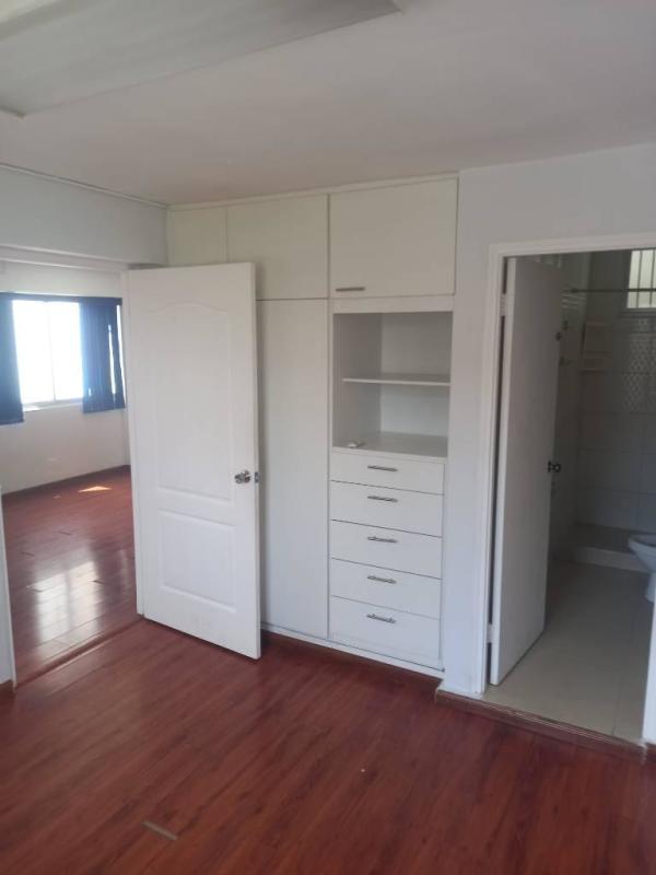 Bedroom with wood flooring, built-in wardrobe, white walls apartment Parque Lefevre Panama City