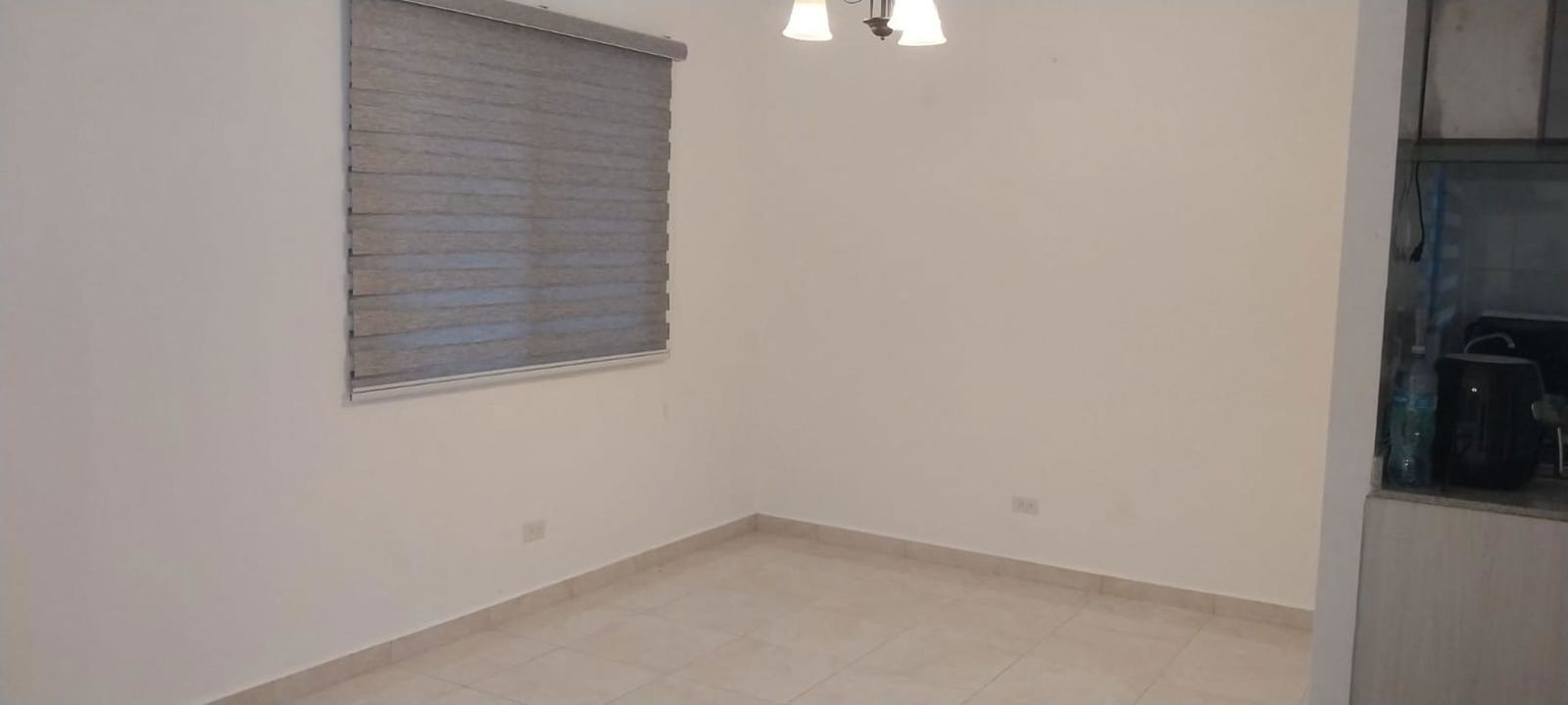 Minimalist living area with tiles and window blinds in Cumbres del Lago Panama City