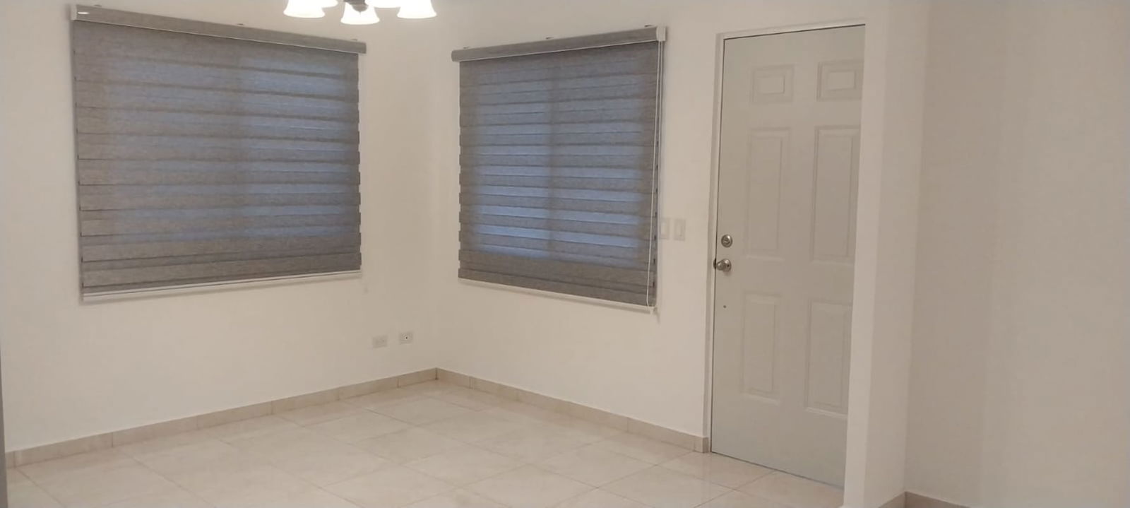 Modern entry area with tiled floor, windows and white door in Cumbres del Lago Panama City
