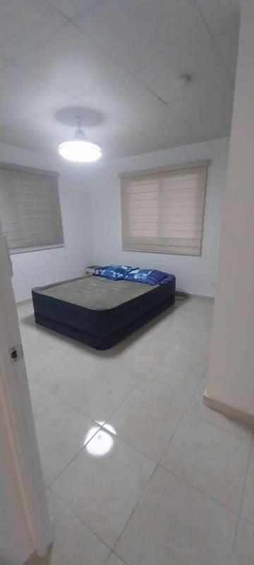 Bright bedroom with double bed, tiled floor and windows with blinds in Cumbres del Lago Panama City