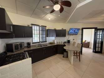 Simple bright living area with large windows, ceramic tiles and ceiling fan in Herrera Panama