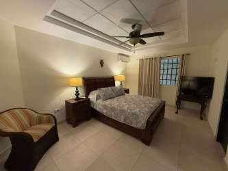 Bathroom with glass shower, tile walls, and vanity in Panama Herrera home
