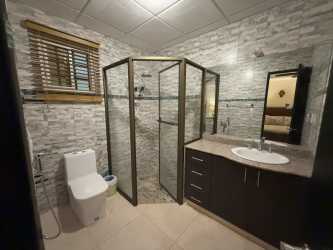 Traditional bedroom with fan, large window, curtains, and closet in Chitré home