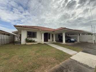 One-story house with covered carport, lawn, tile roof, and arched entrance in Brisas del Sur Chitré