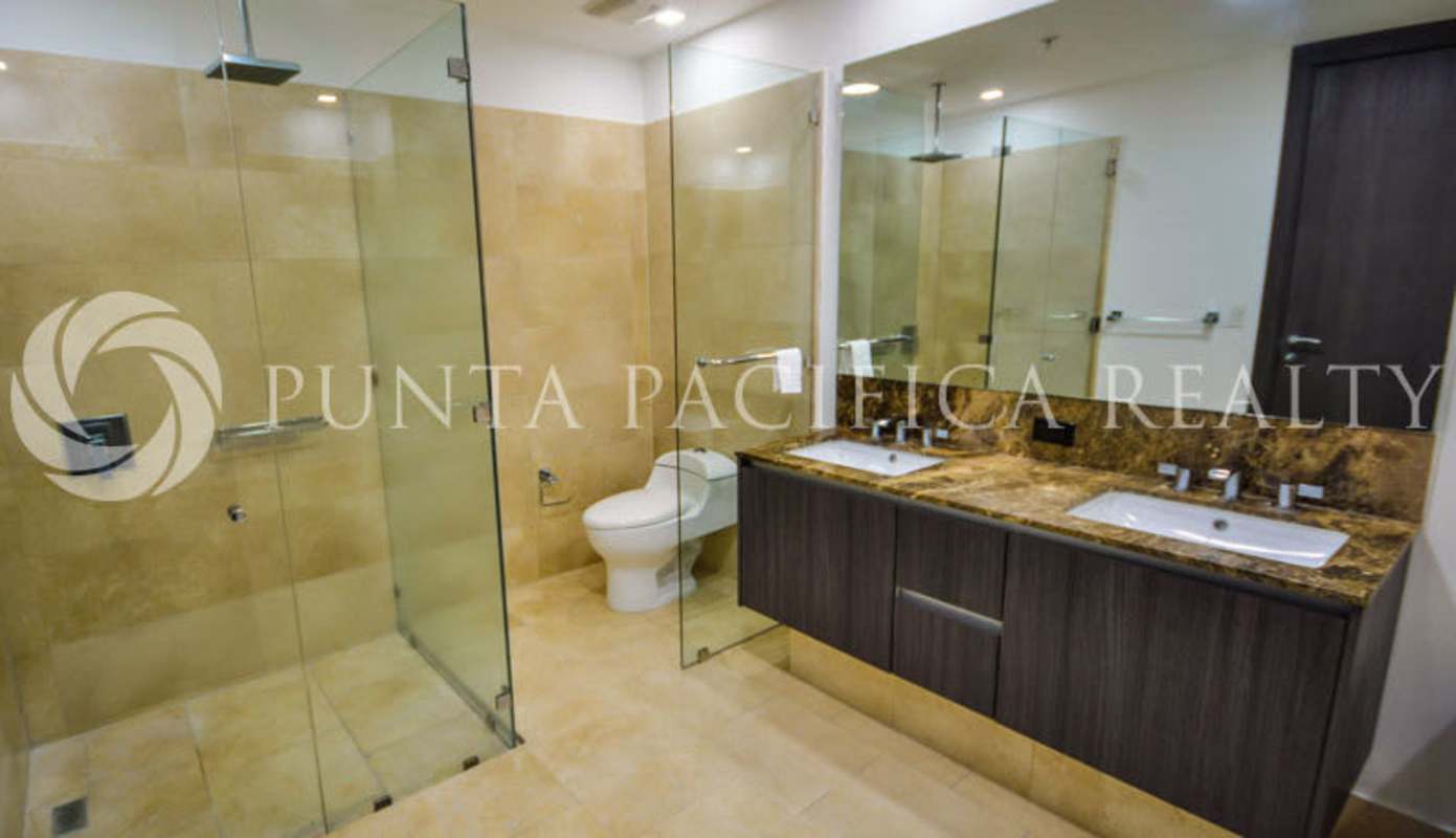Modern bathroom with glass-enclosed shower double sinks marble finish at The Ocean Club Panama