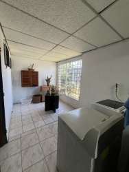 Laundry area with glass block window, washing machine space, storage cabinet in Arraiján house