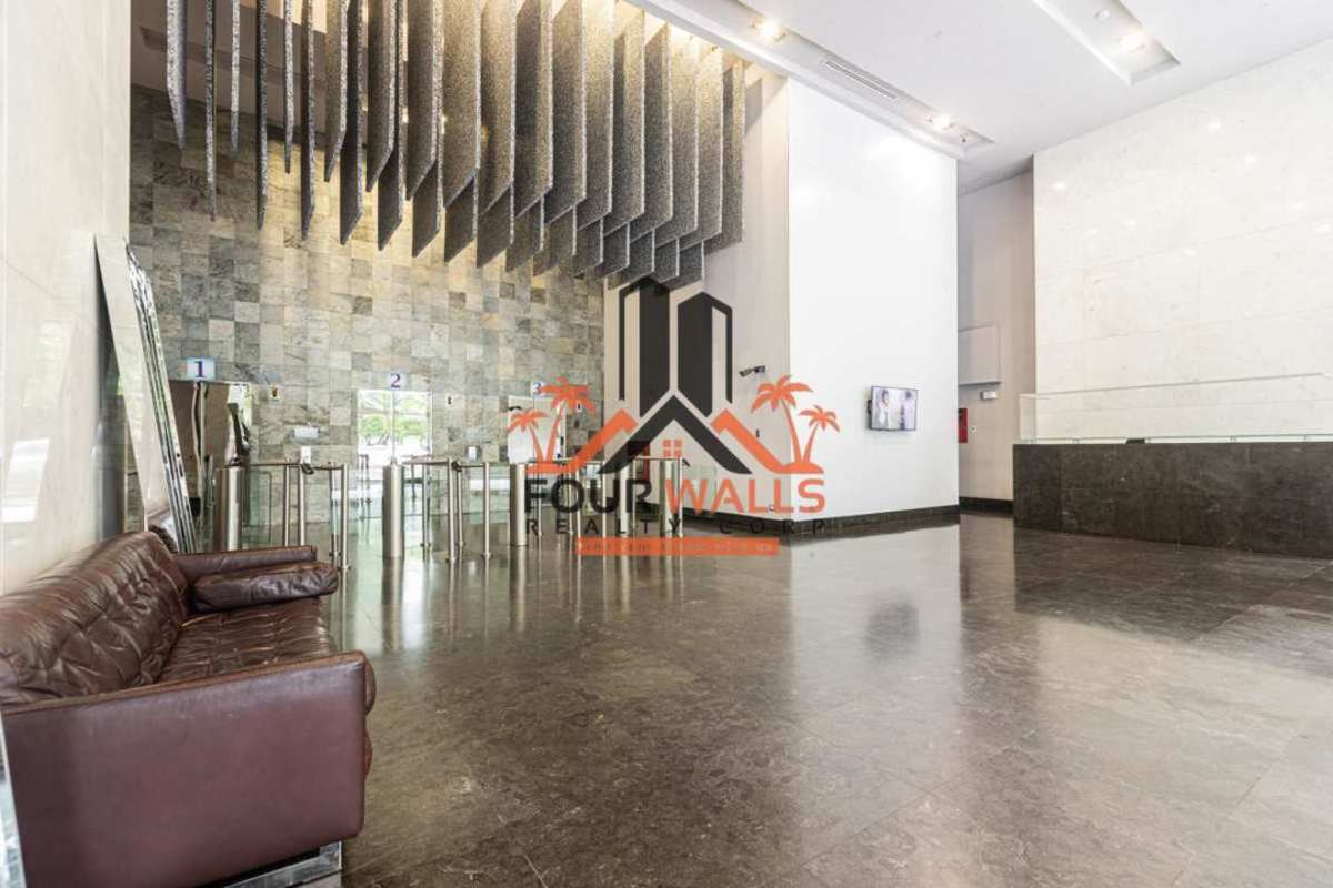 Modern kitchenette equipped with fridge granite countertop and seating in PH Office One Obarrio