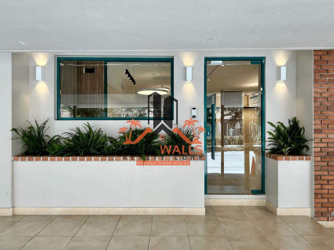 Exterior modern building glass entrance with planters and lighting PH Ejecutivo Panama City