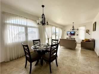 Open concept living and dining area with large windows at Tucan Country Club apartment Panama