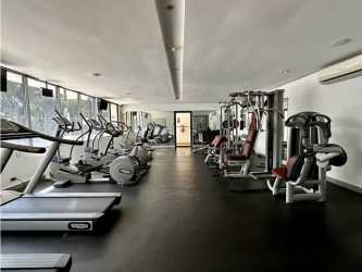 Community swimming pool surrounded by lush garden and lounge area at Tucan Country Club Panama