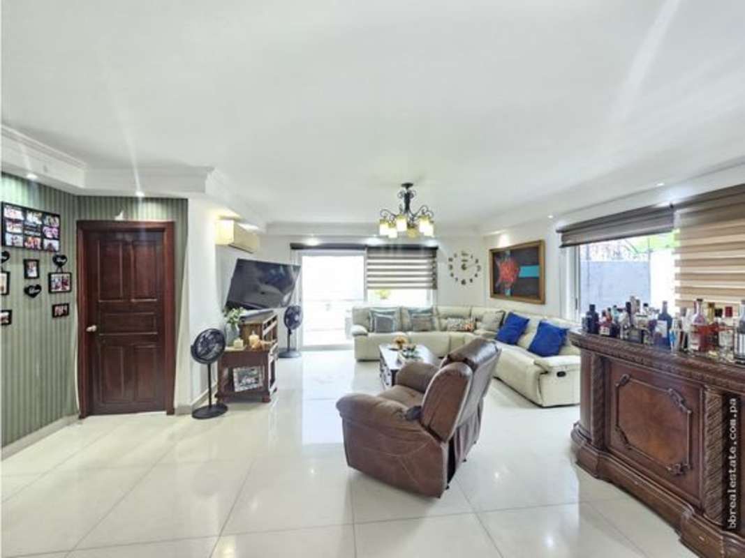 Large bedroom with balcony access, blue upholstered bed, garden view Altos del Golf Panama