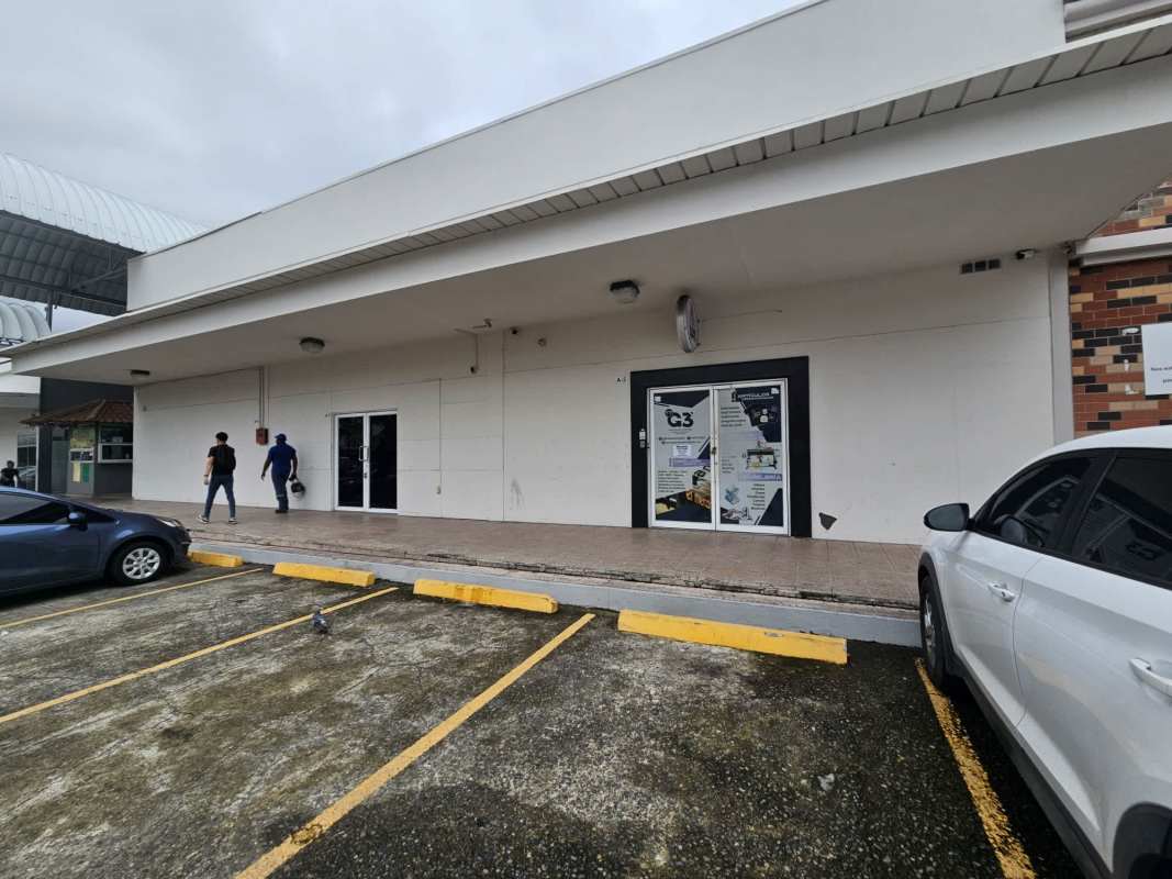 Multiple cars in drive-thru lane and shopping center parking at Los Pueblos, Panama City