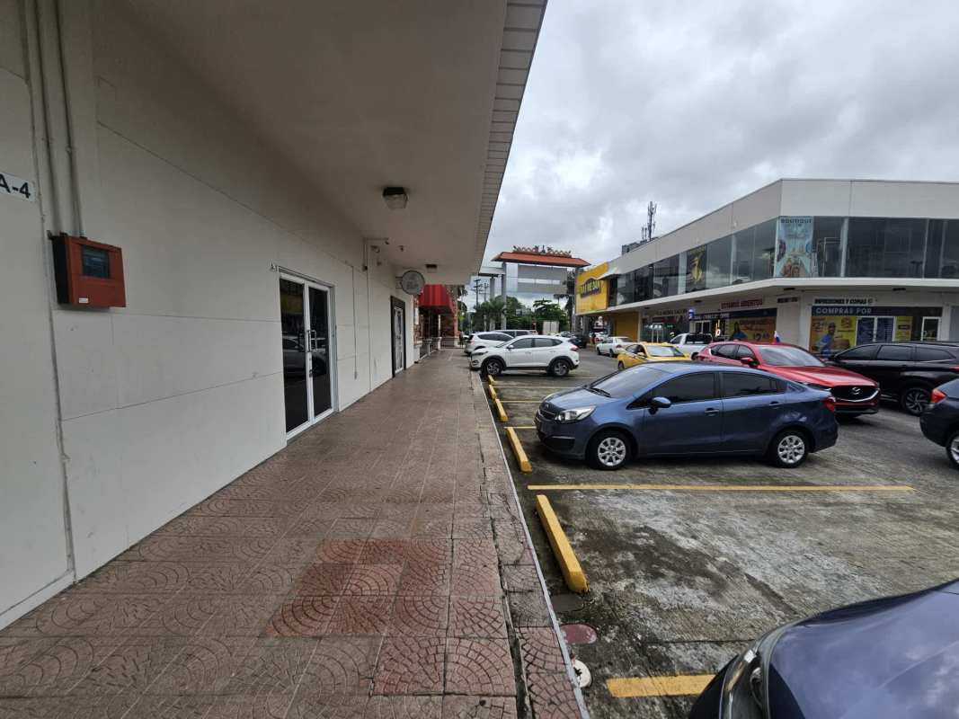 Large parking lot and multiple storefronts at Los Pueblos Shopping Center in Panama City