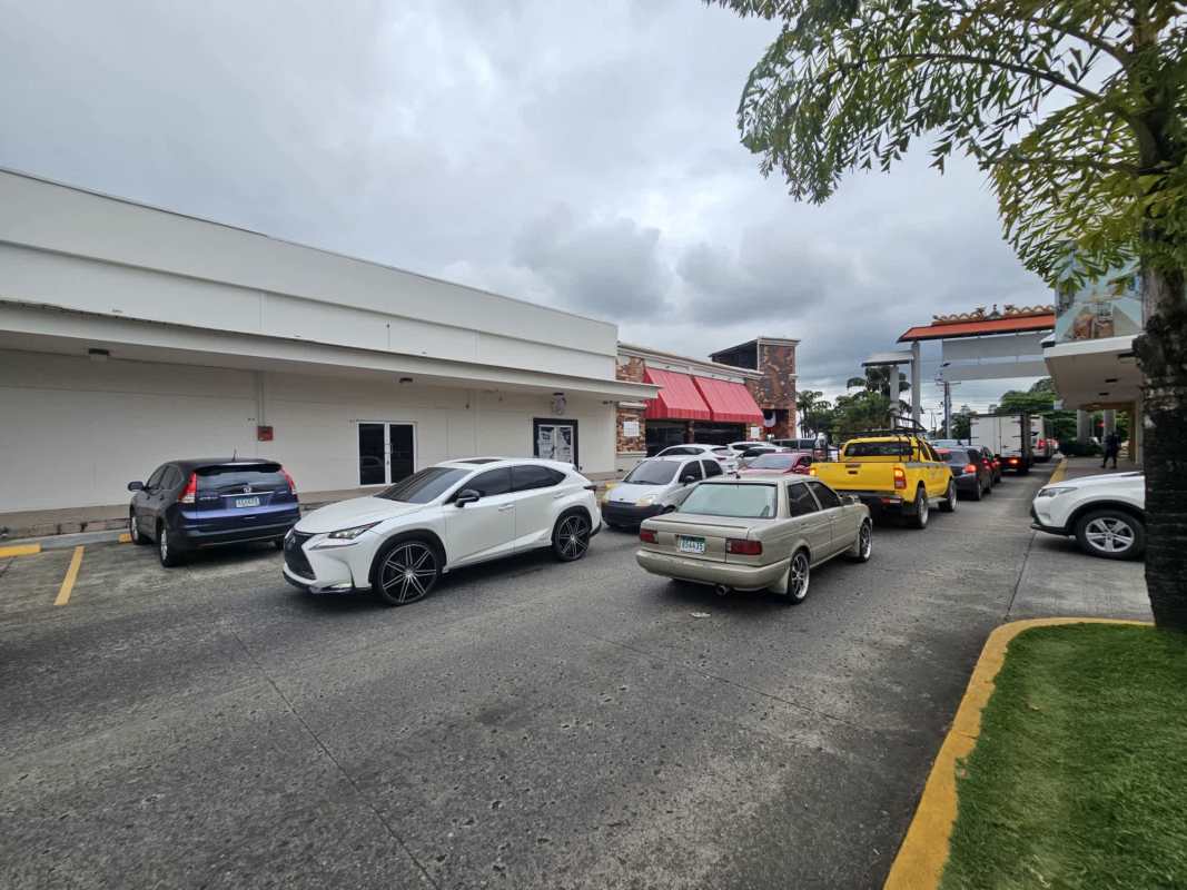 Commercial retail plaza with storefronts and parking lot in Los Pueblos Panama