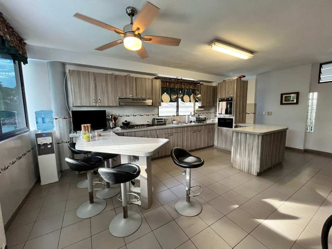 Contemporary living room with double height ceiling, loft, spiral stairs, natural light Dos Mares Panama