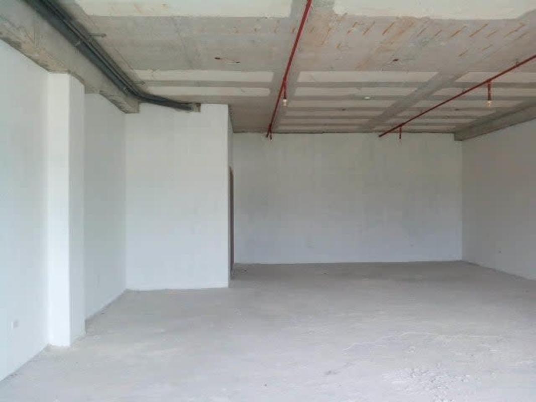 Bare open commercial space with exposed concrete ceiling and conduits Terrazas de Albrook