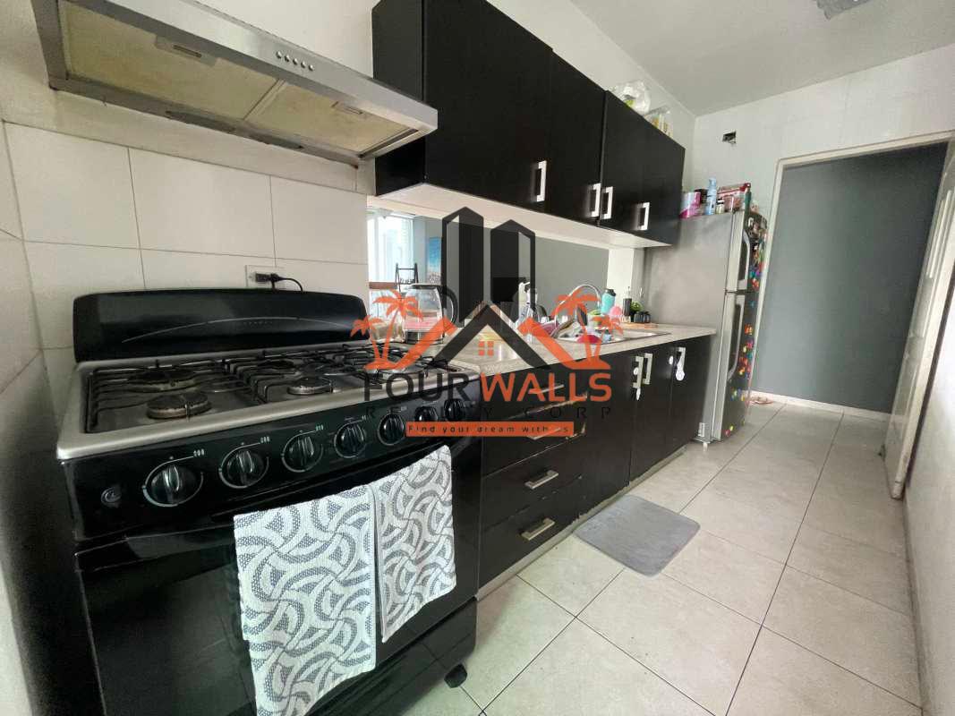 Compact kitchen with gas stove, refrigerator, cabinets, tile, PH The Seawaves