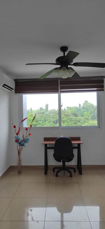Minimalist home office or bedroom space with large window, ceiling fan, AC, city view in PH Urbis Tower Panama City