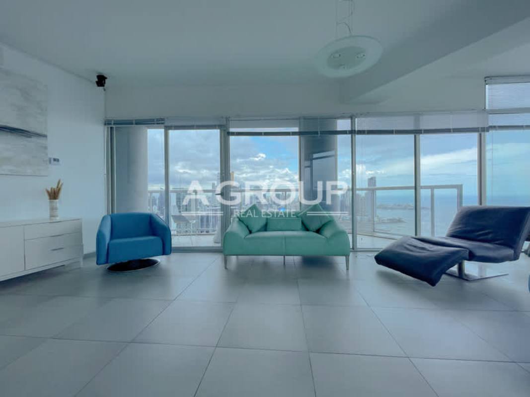 Large living area with floor-to-ceiling windows overlooking ocean and skyline in PH Yacht Club Panama City