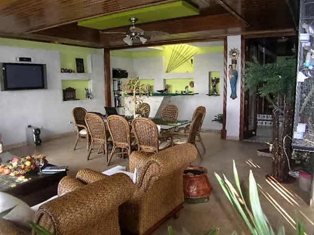 Traditional dining room with green walls, glass-fronted cabinets and elegant furnishings in Dos Mares Panama